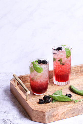 Delicious beverage with blackberries on wooden tray