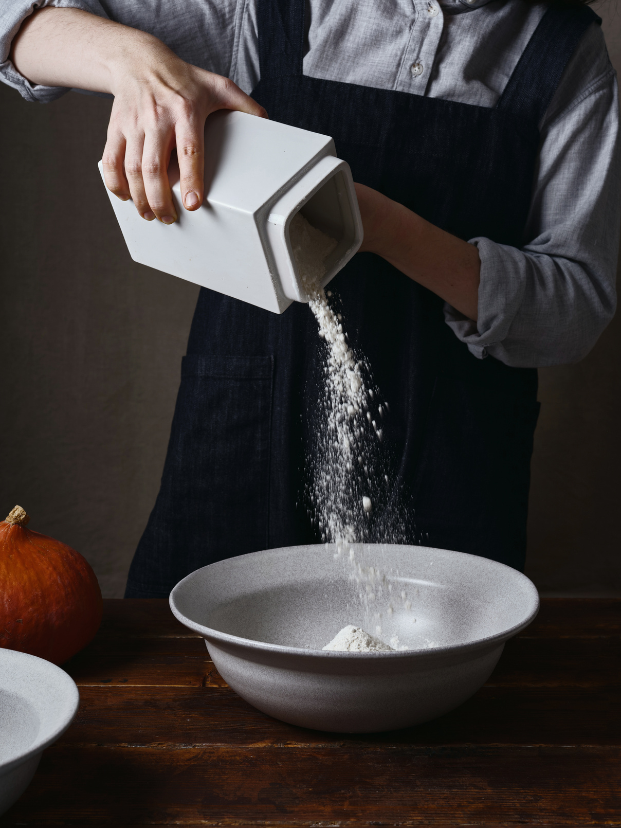 Person Pouring Flour into a Bowl